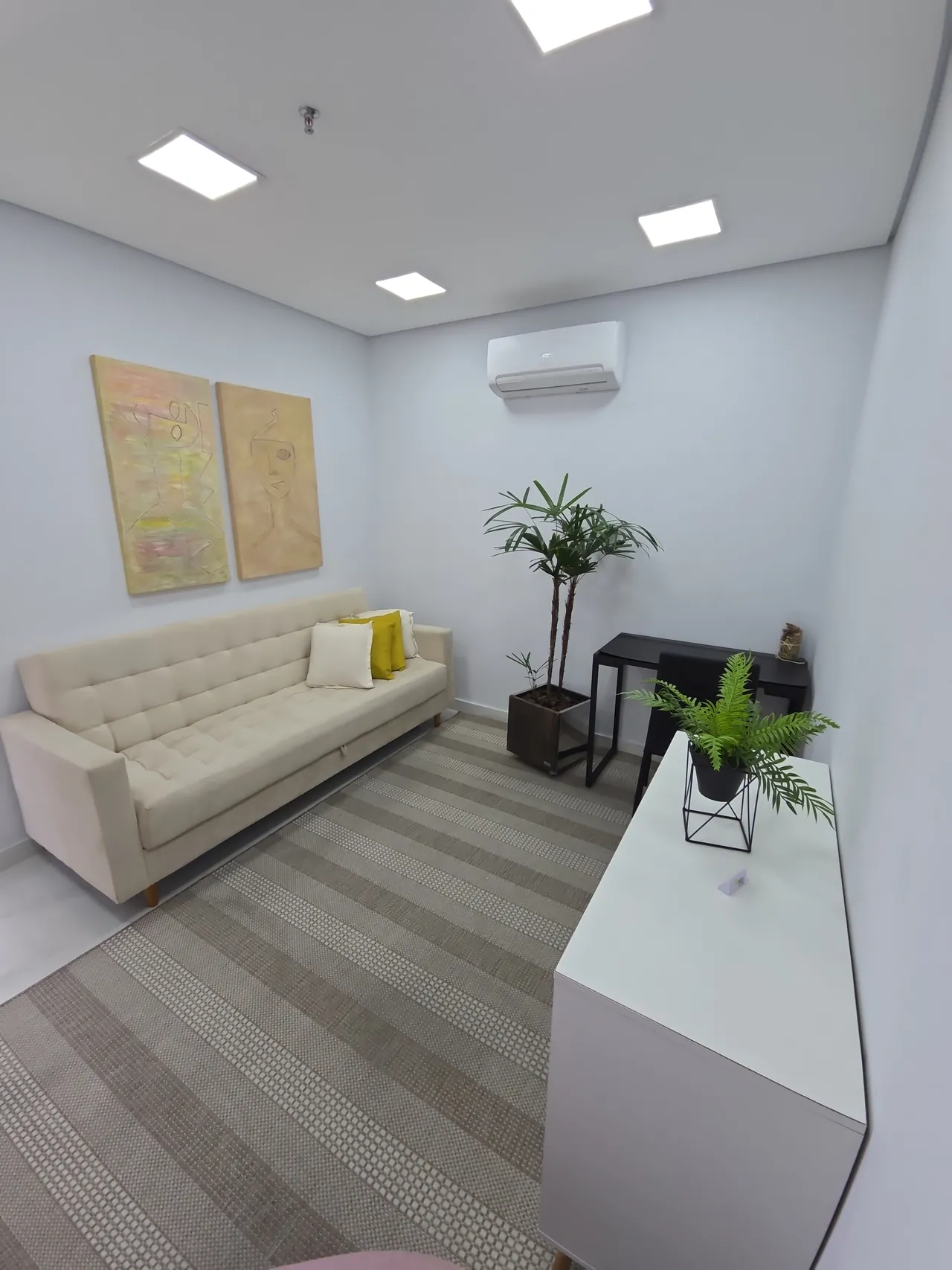 Sala de terapia com sofá e quadros